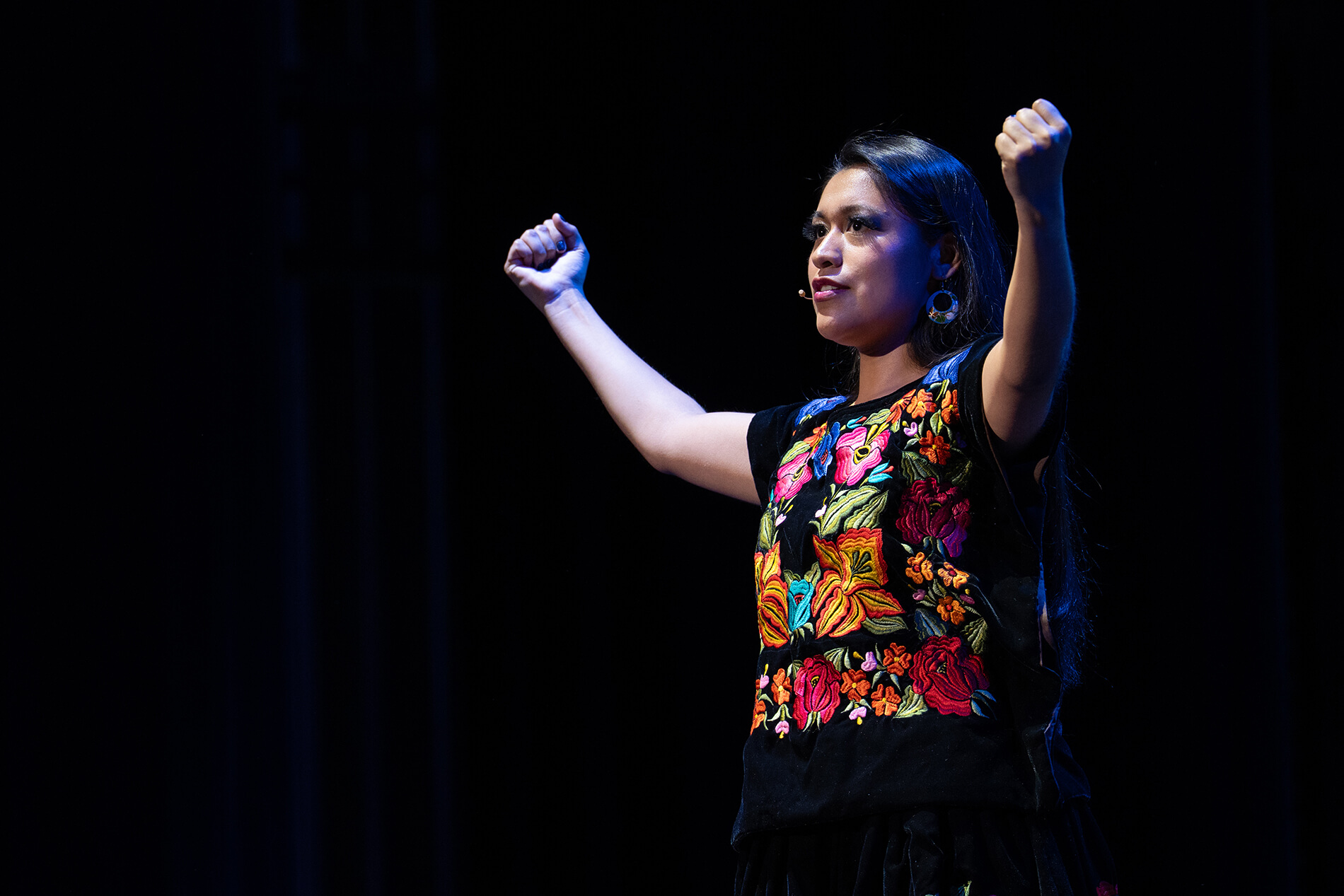 Opera UCLA Performer Olivia Salazar in flower print top with her arms extended in fists.