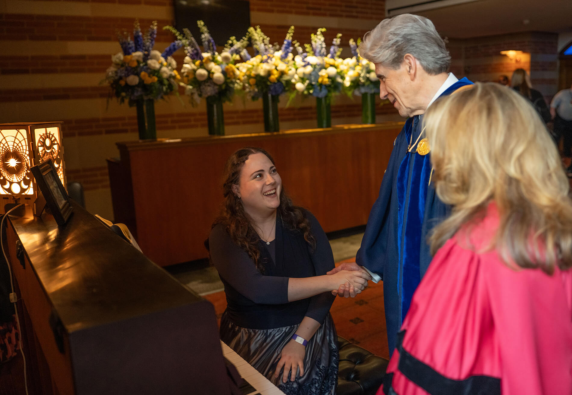 Chancellor Frenk greets the pianist. Dr. Knaul looks on.