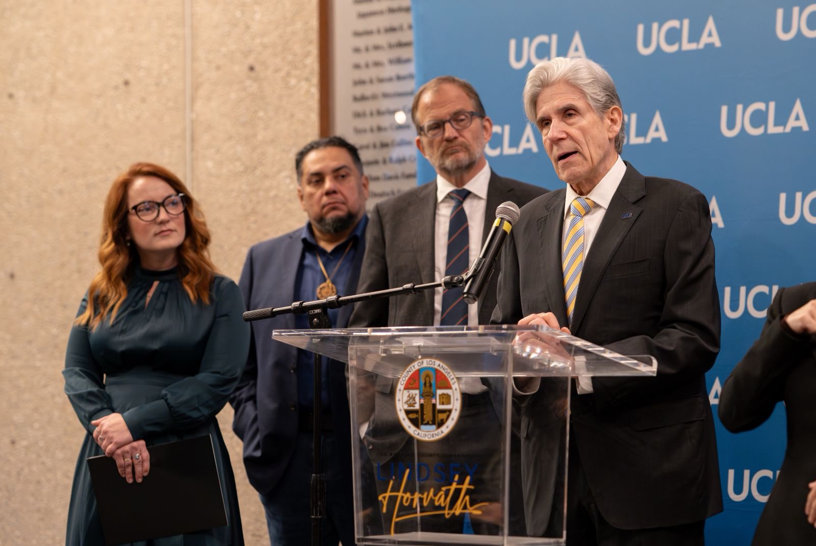 UCLA Chancellor Julio Frenk, at the podium, joined L.A. Country Supervisor Lindsey Horvath (far left) at a news conference announcing the launch of the independent blue-ribbon commission.