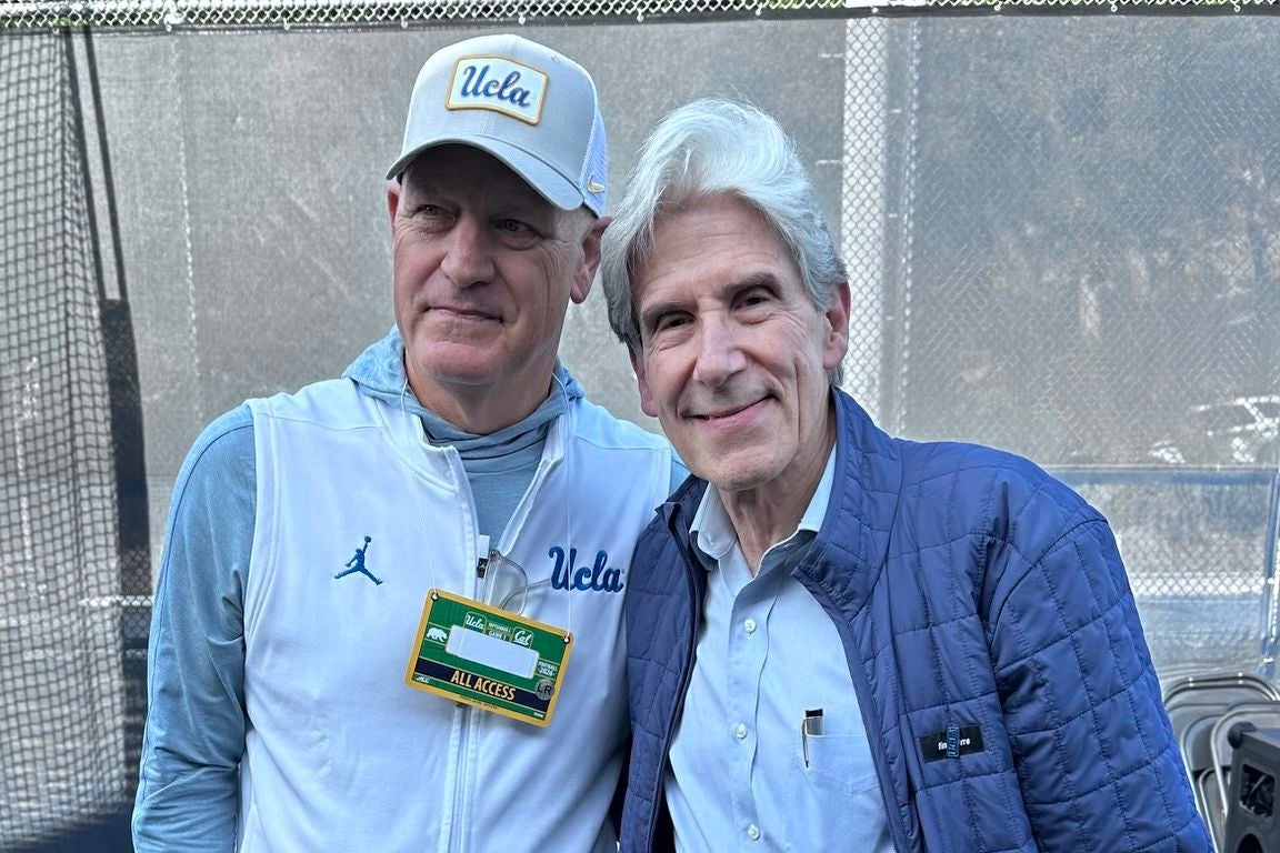 UCLA Chancellor Julio Frenk, right, smiles beside Tim Harris, UCLA's CEO and director of athletics, who wears a UCLA cap and jacket before the Bruins' football game against Cal in Berkeley
